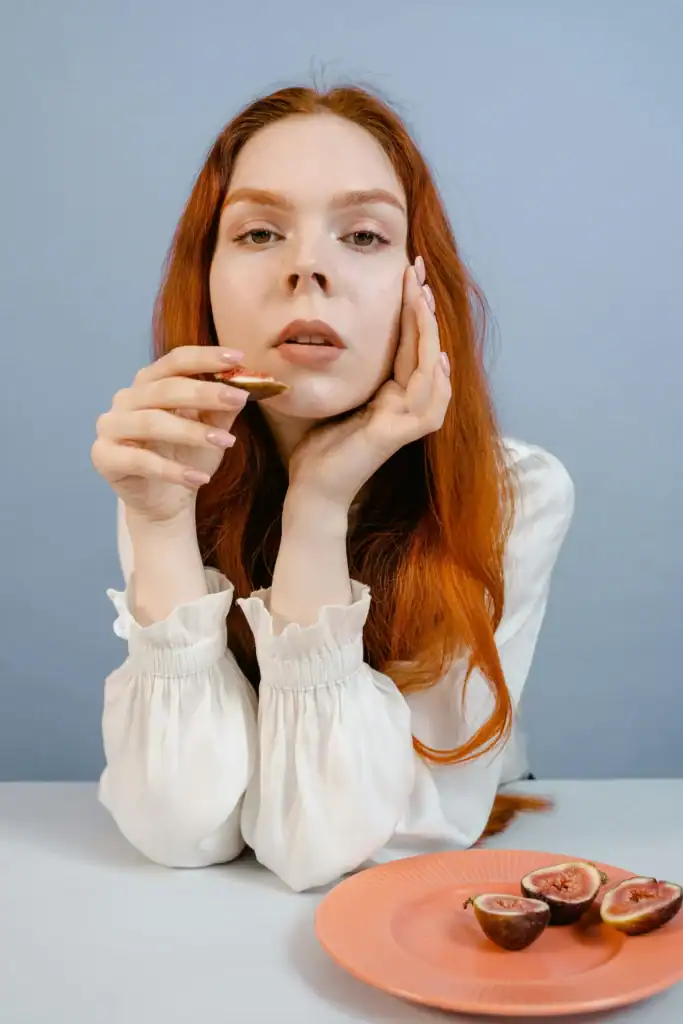 ginger-haired-woman-eating-figs-683x1024