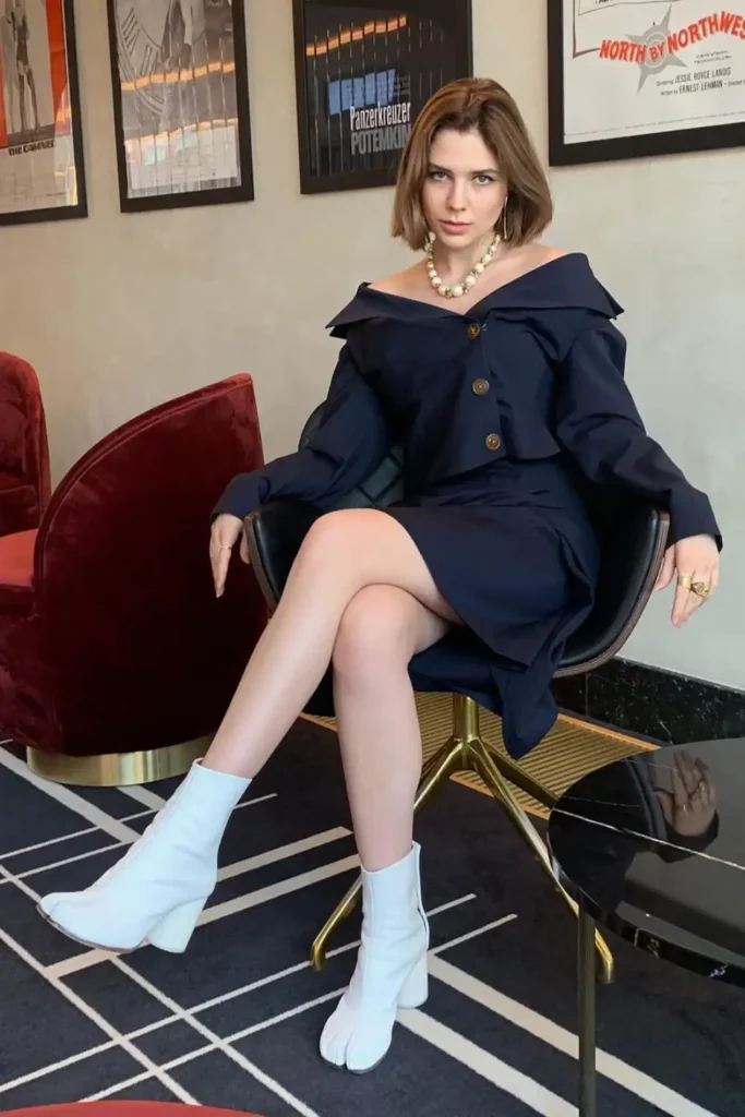 woman posing wearing white tabi ankle boots