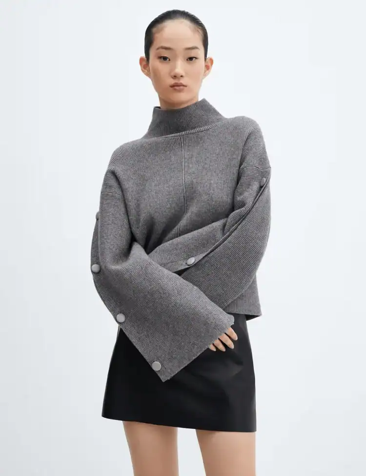 Model poses wearing a grey button-sleeved sweater. TikTok’s ‘Groutfit’ Trend