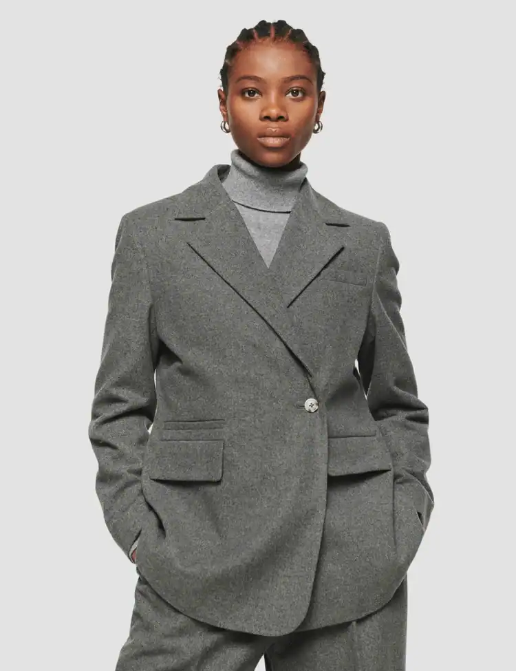model poses wearing a grey wool blazer