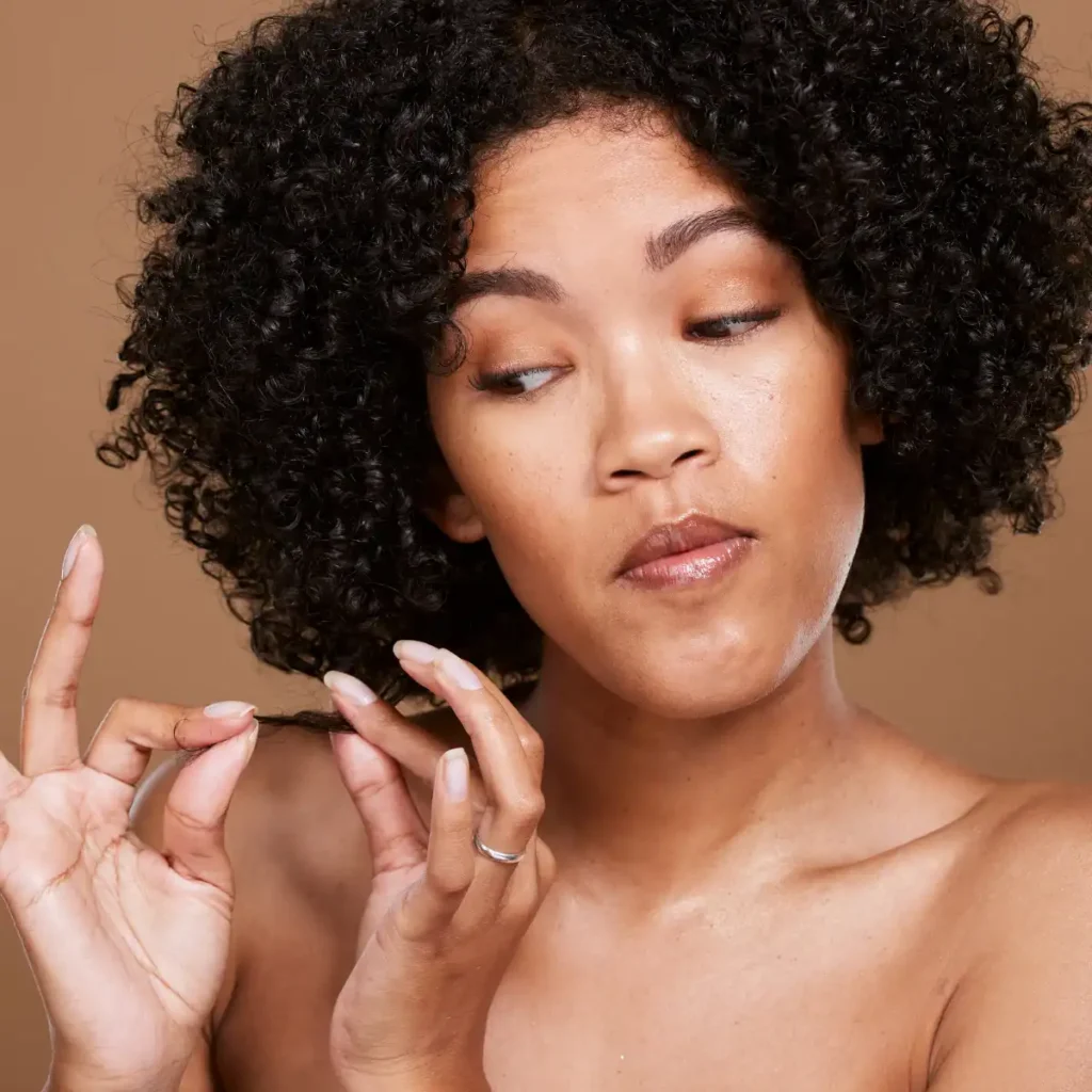 woman with curly hair stretching her hair. best heat protectant products