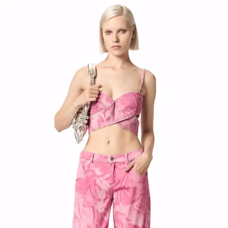 Model poses wearing a pink denim camouflage crop top with matching jeans. Best y2k fashion brands