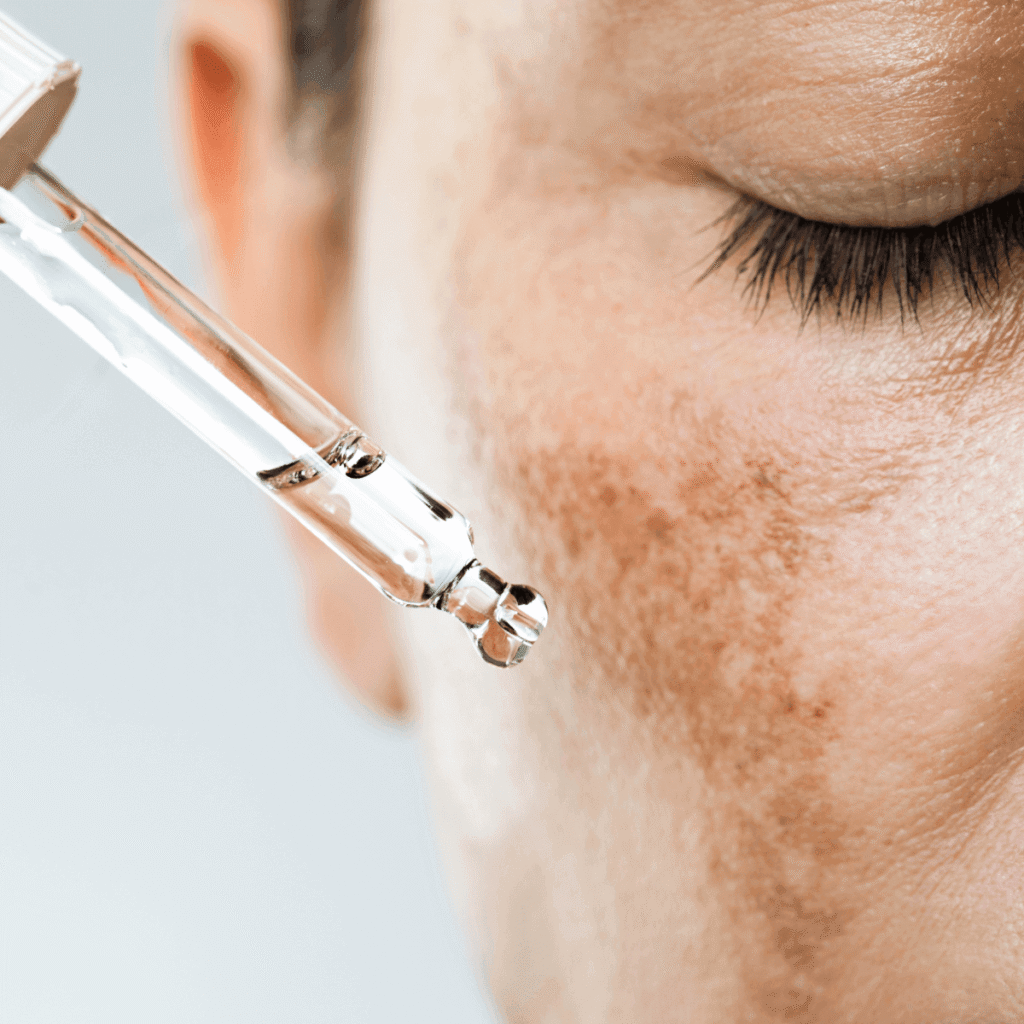 up close shot of a person using a cosmetic pipette to apply a skin care product