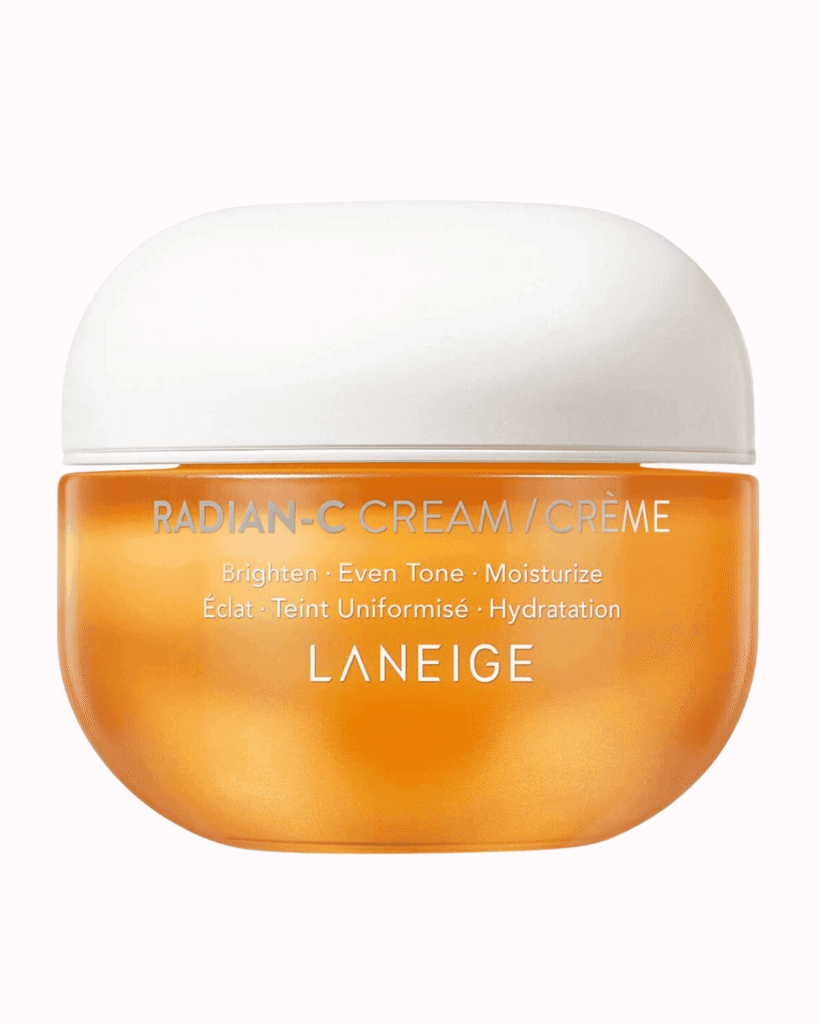 Laniege radian cream orange and white bottle on a plain pastel pink background