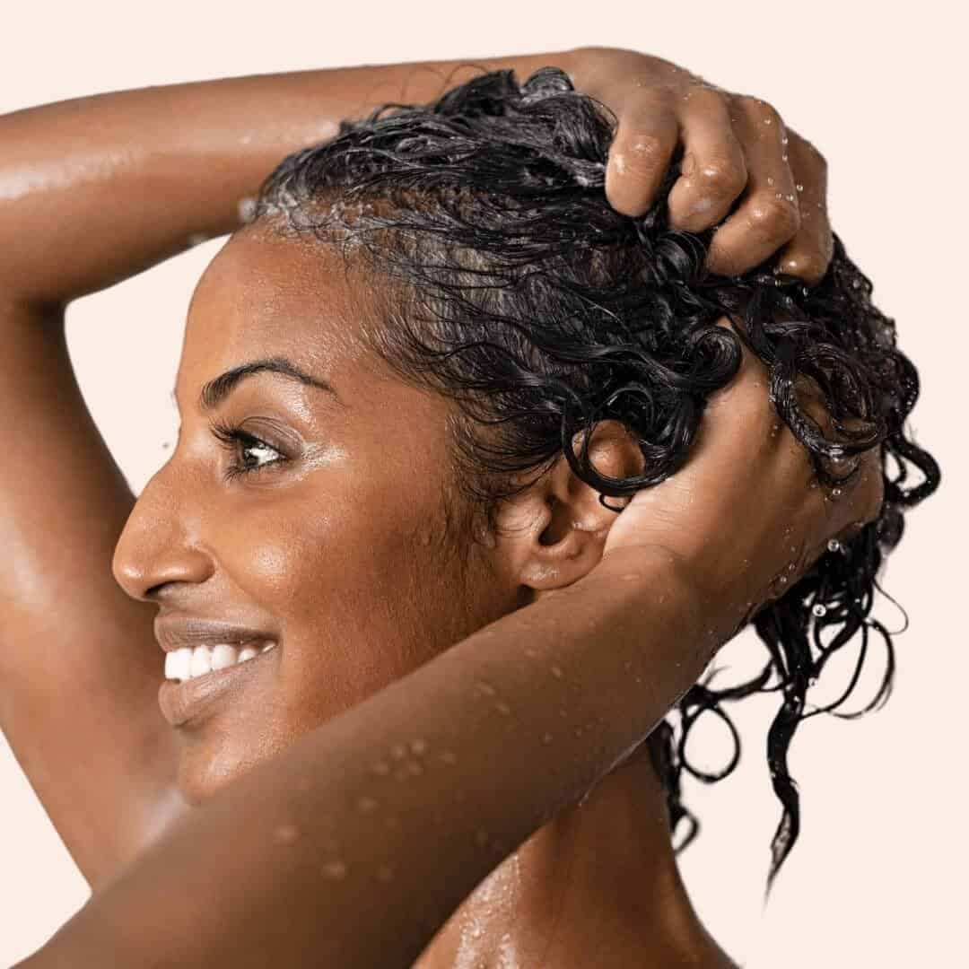 side view of a woman shampooing her hair