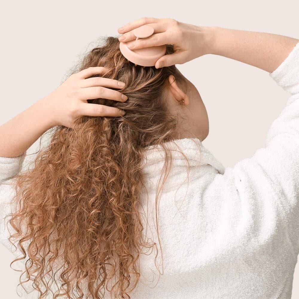 Young Woman Using Hair Scalp Massager.