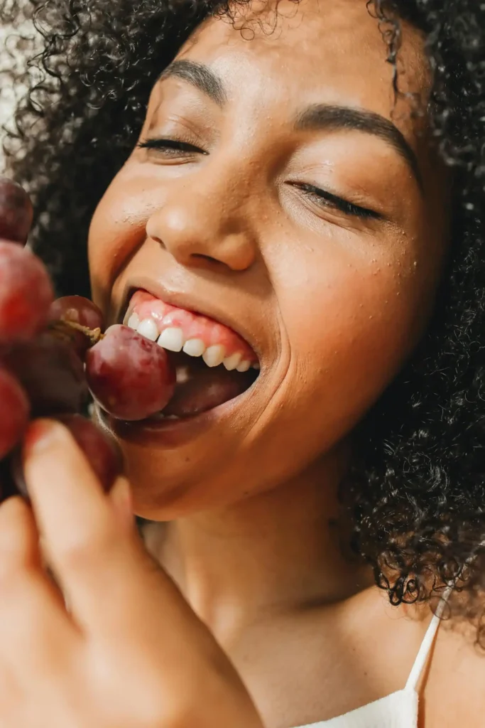 up close shot of woman with curly hair eating berries