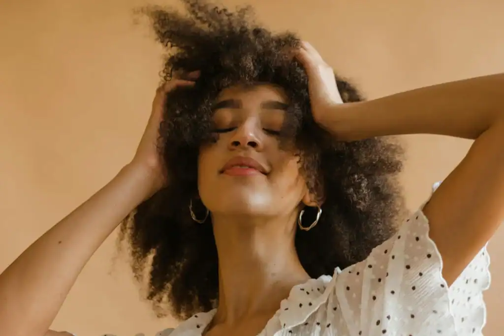 Woman-touching-her-with-curly-hair-with-her-eyes-closed-1024x683