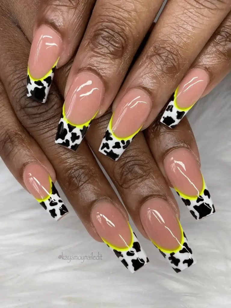 black and white cow print nail design with neon green
