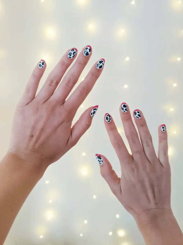 black and white cow print nails with pink accent