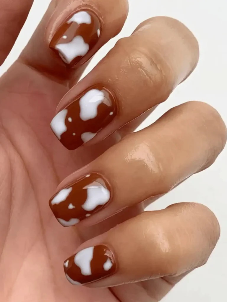 brown and white cow print nail design
