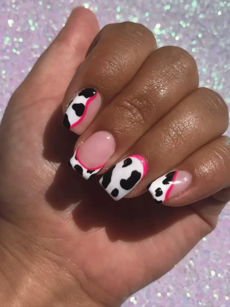 cow print nails with pink neon accent