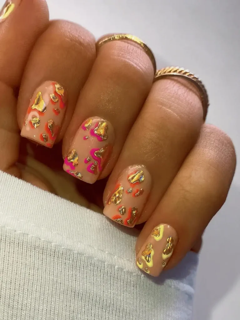 gold and neon orange and pink neon cow print nails