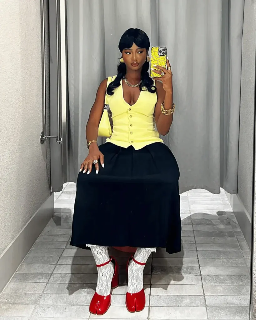 black woman wearing a quirky outfit and red tabi shoes