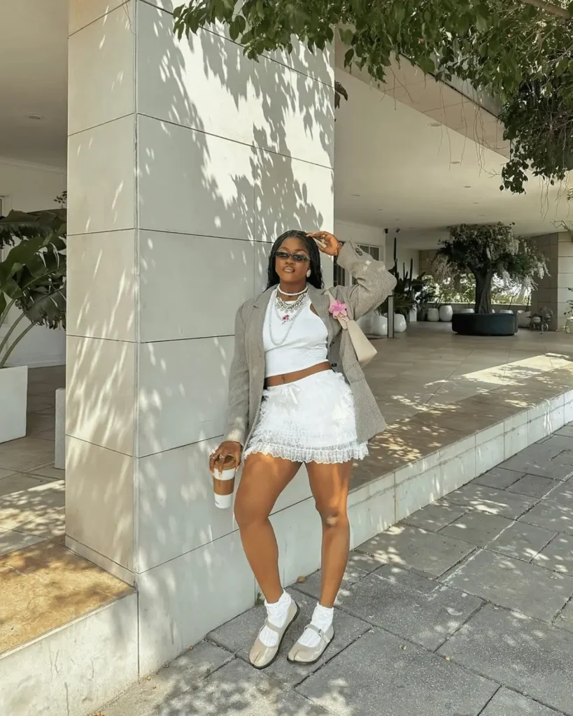 black woman with braids wearing a white skirt coord and beige tabi shoes