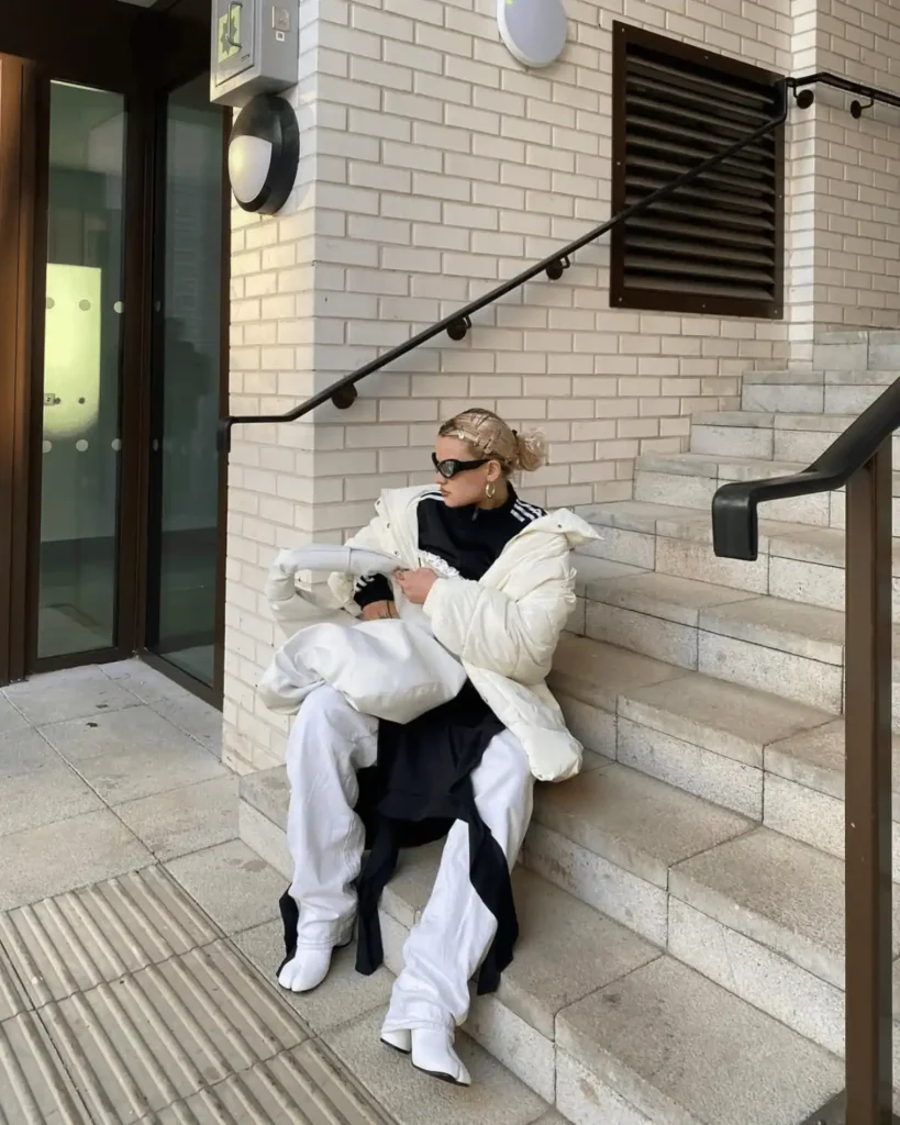 blonde woman wearing white puffer coat and white jeans and tabi shoes