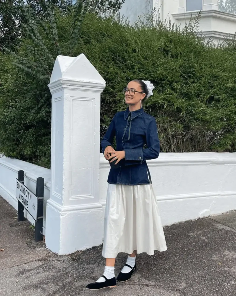 woman wearing longline peter pan collar denim jacket and long white skirt with black tabi shoes