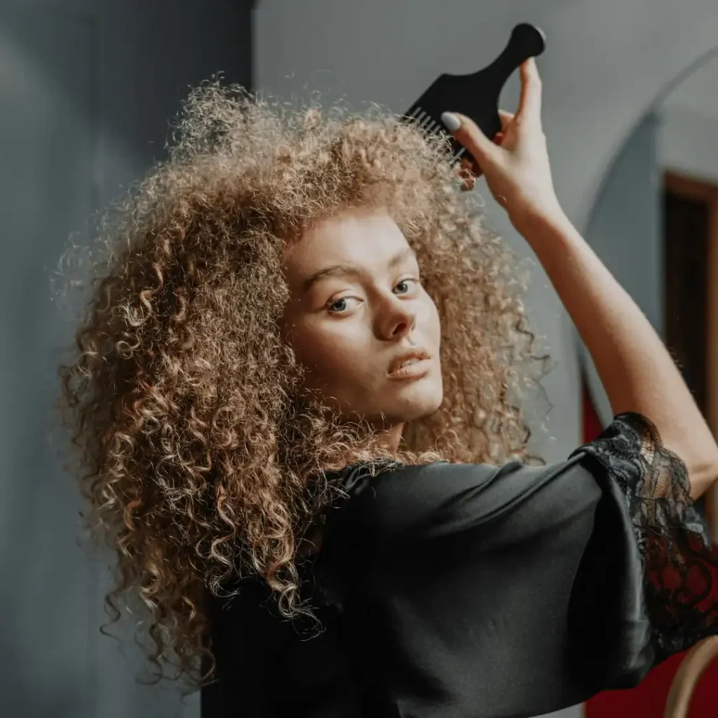 woman detangling her curly hair