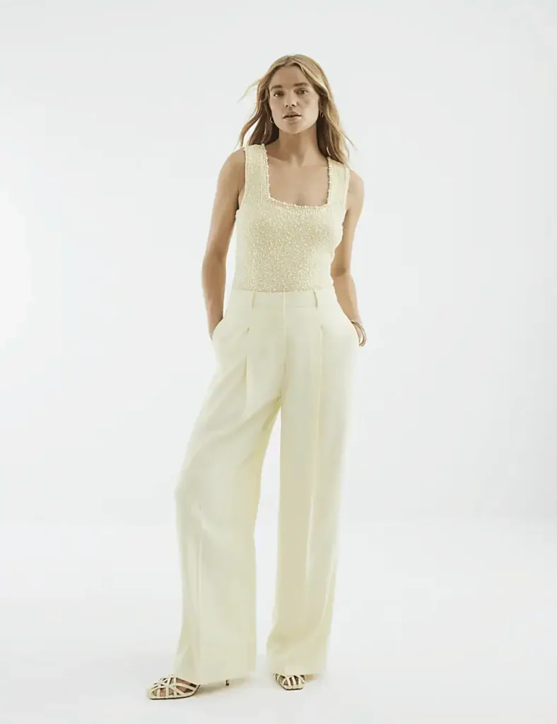 Model wearing matching butter yellow top and linen trousers
