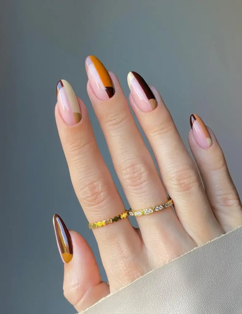 Nude nails with mustard, burgundy, and chocolate color block French tips.