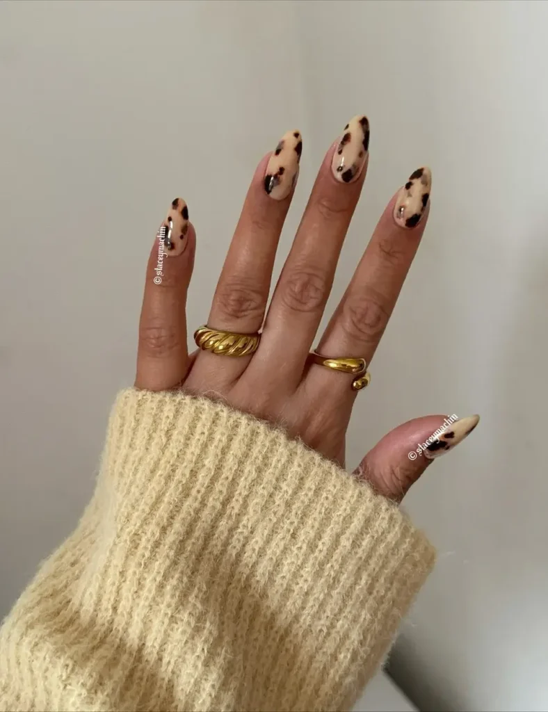 Cream base nails with light brown and black tortoiseshell spotting.