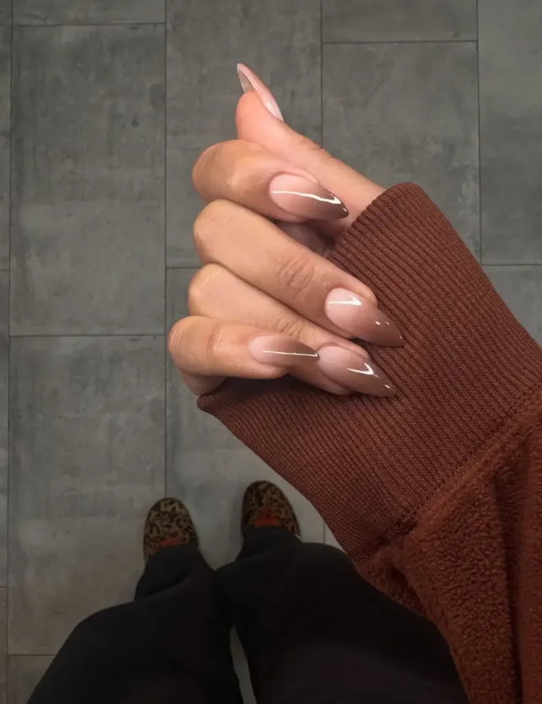 Almond nails with soft brown-to-nude ombrรฉ French manicure design.