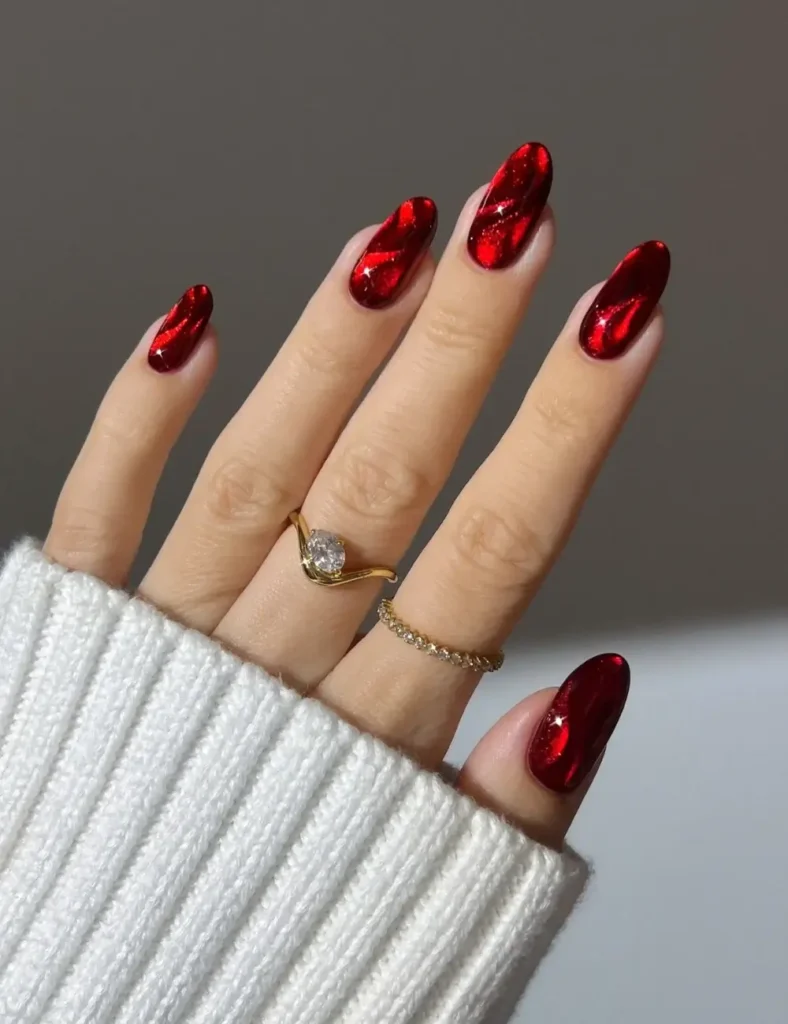 Almond nails with a high-shine, molten red chrome finish