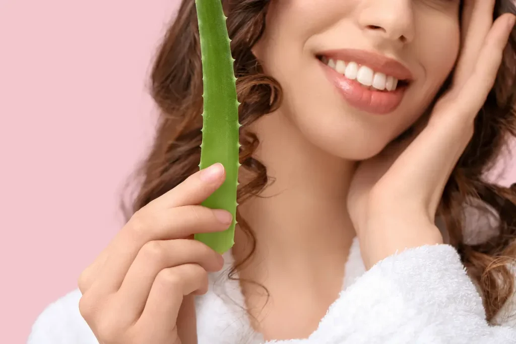 Beautiful Young Woman Holding Aloe Vera on Pink Background