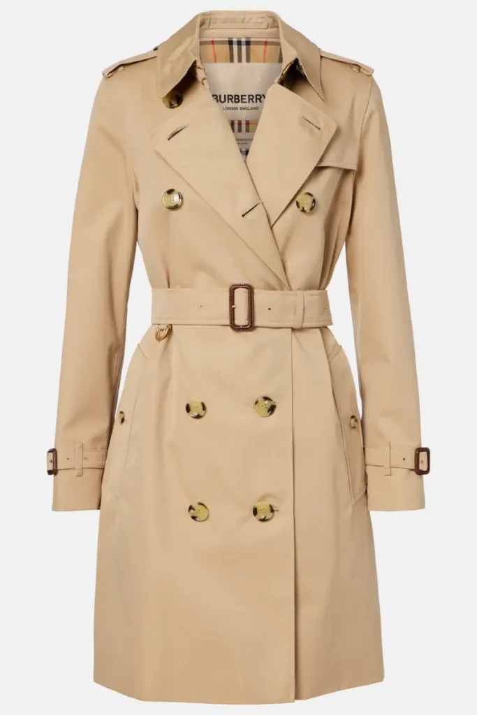 Burberry honey beige cotton gabardine trench coat with a double-breasted front, epaulets, and a belted waist on a plain background