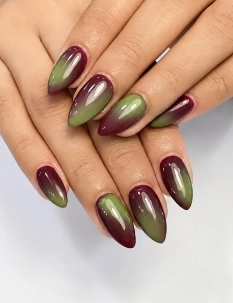 Glossy almond nails with a gradient aura blending deep burgundy and olive green