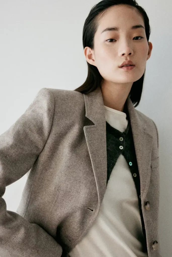 Woman wearing a Mango beige tailored wool-blend blazer with notched lapels and tortoiseshell buttons, styled as a matching set