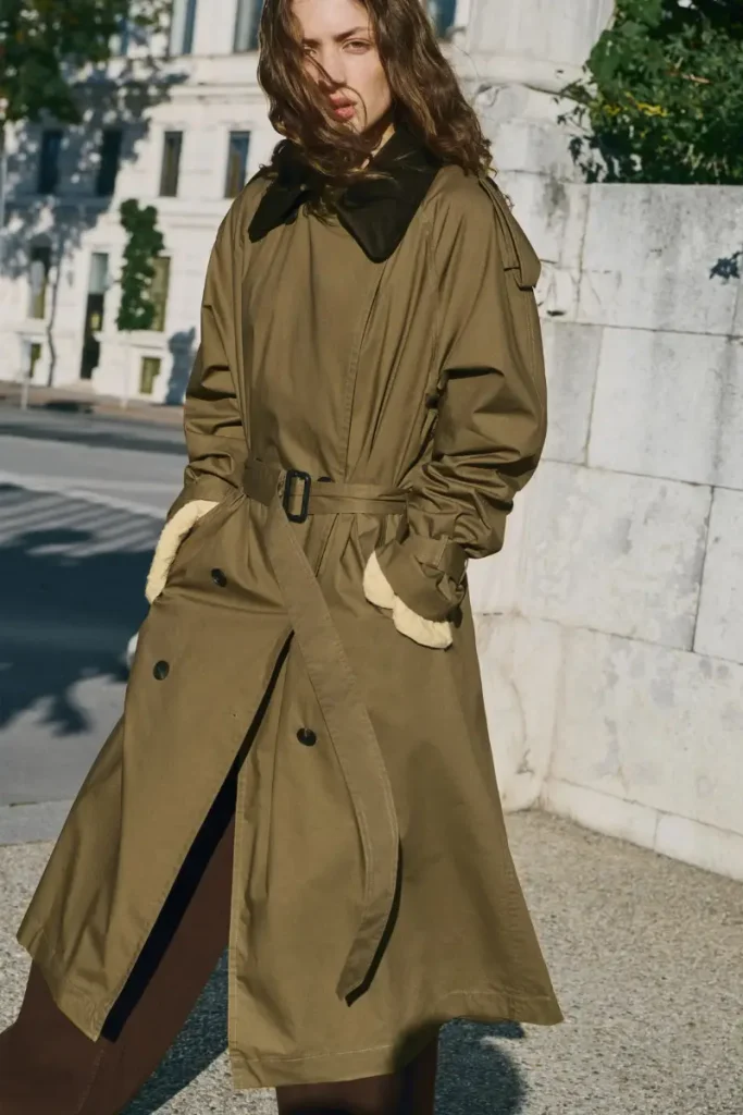 Woman wearing a Mango olive khaki double-breasted cotton trench coat with a brown corduroy collar and buckled belt